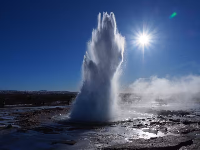 Strokkur geyser erupting in Haukadalur on a Private Golden Circle Tour Iceland under bright blue sky