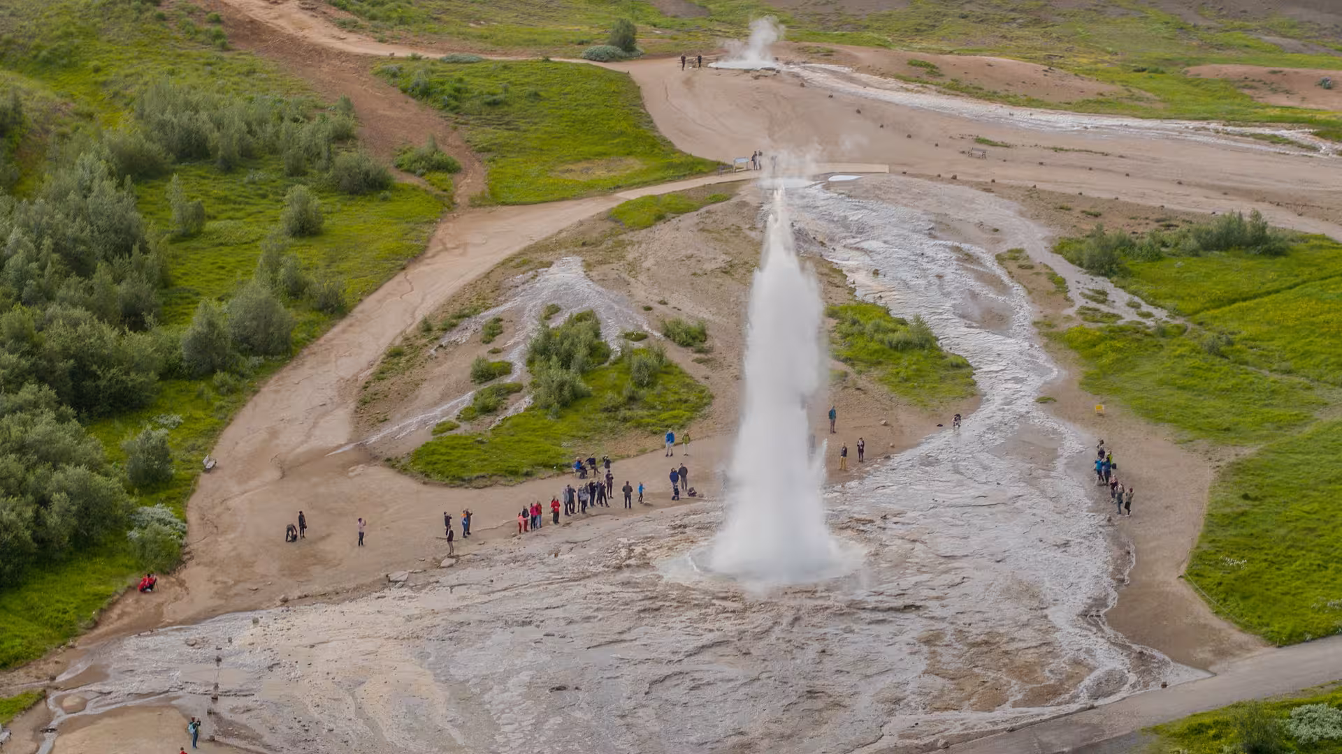 Tourists gathered around the erupting Strokkur geyser in Iceland, a highlight of the 7-day West and South tour.