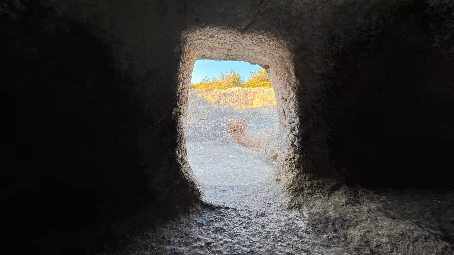 View from inside a stone chamber at Su Crucifissu Mannu, showcasing the ancient archeological site in Porto Torres.