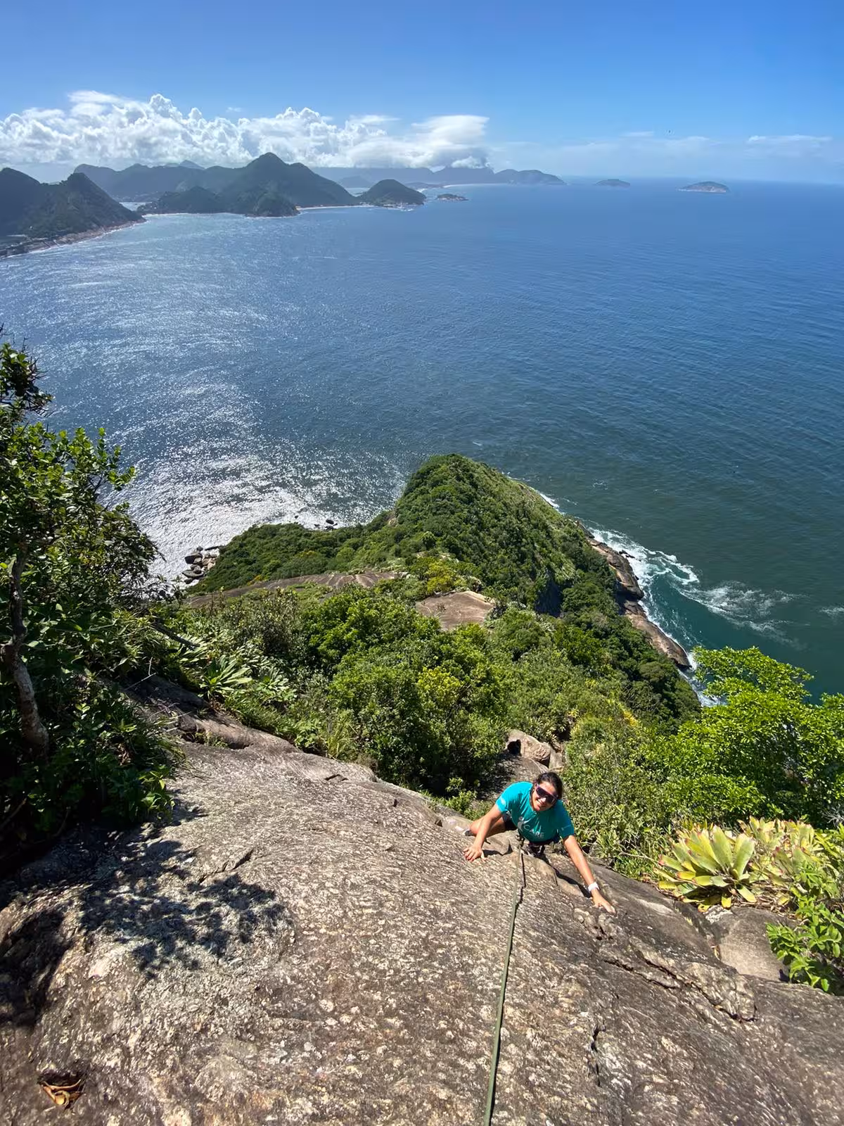 Climber scaling Sugarloaf Rock with stunning ocean views, ideal for all levels of rock climbing enthusiasts.