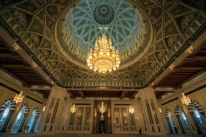 Grand chandelier and ornate Islamic dome inside Sultan Qaboos Grand Mosque, a highlight of a half-day Muscat city tour in Oman