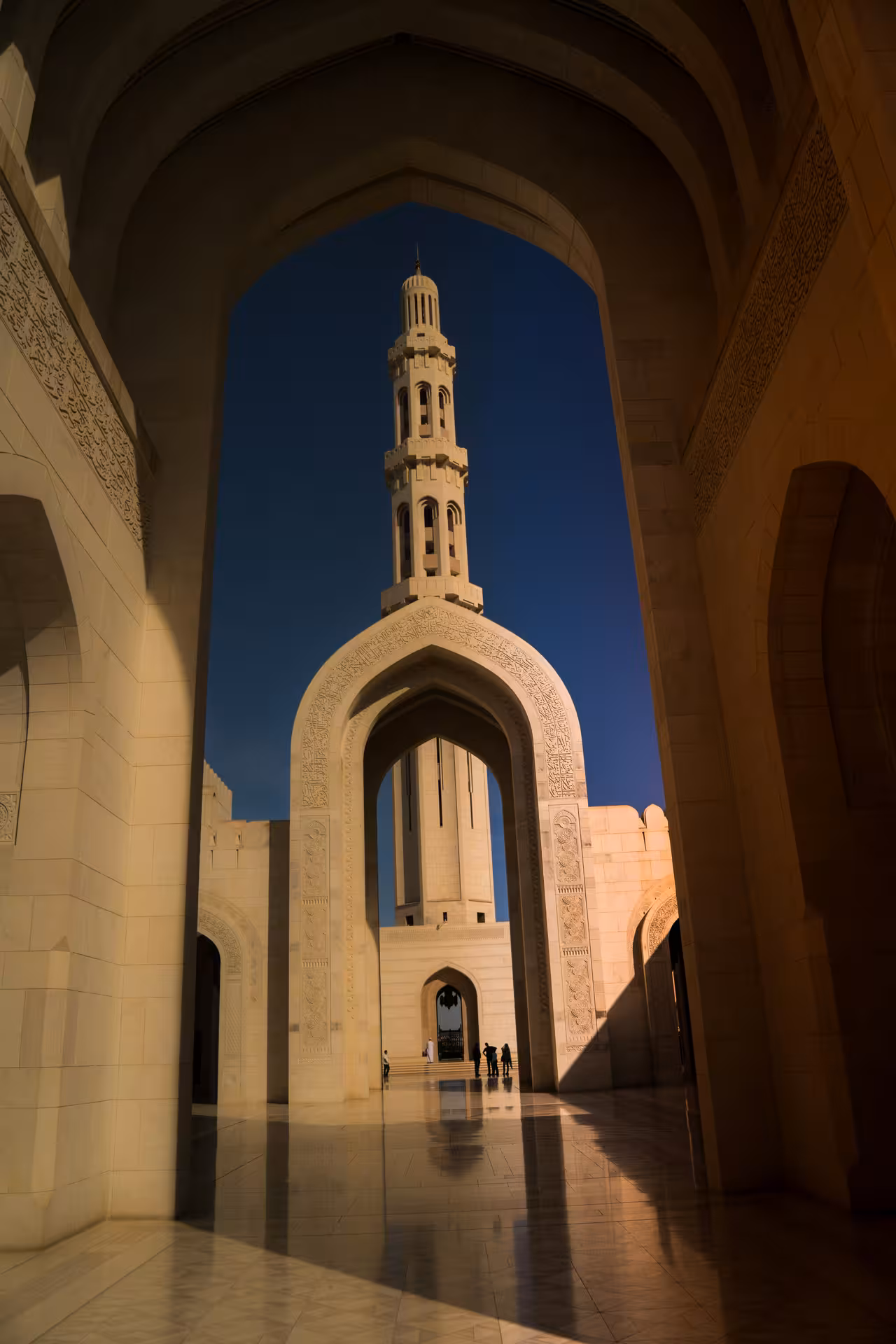 Dramatic view of Sultan Qaboos Grand Mosque minaret framed by arches on a guided private half-day Muscat city experience