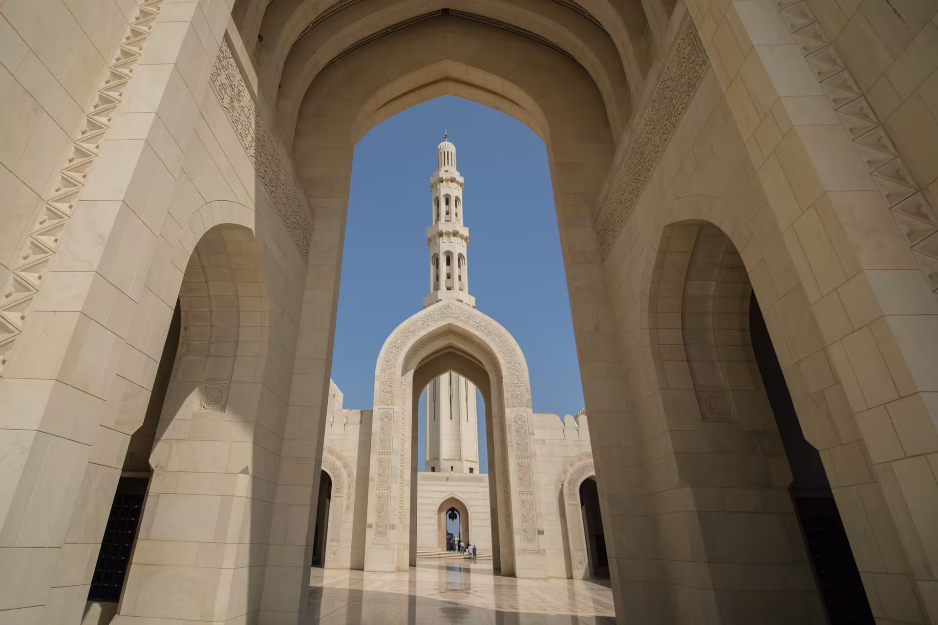 View of Sultan Qaboos Grand Mosque arches and minaret in Muscat, a key sightseeing stop with private chauffeur tours