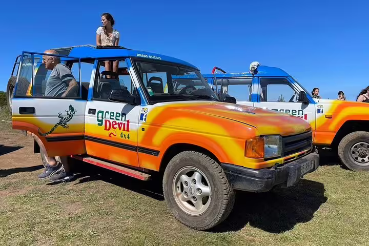 Colorful 4x4 safari vehicle with tourists ready for a Sunny Southwest adventure exploring rum, banana, waterfall, and lighthouse.