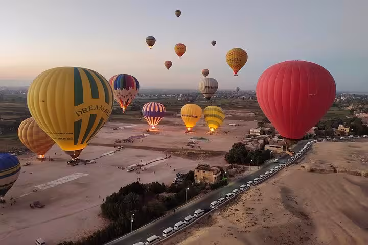Hot air balloons rise majestically over Luxor West Bank at sunrise, offering breathtaking views of the Egyptian landscape.