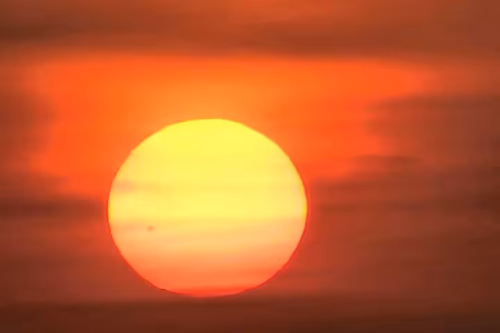 Vibrant sunrise over Luxor West Bank, casting a golden hue perfect for a magical hot air balloon adventure.