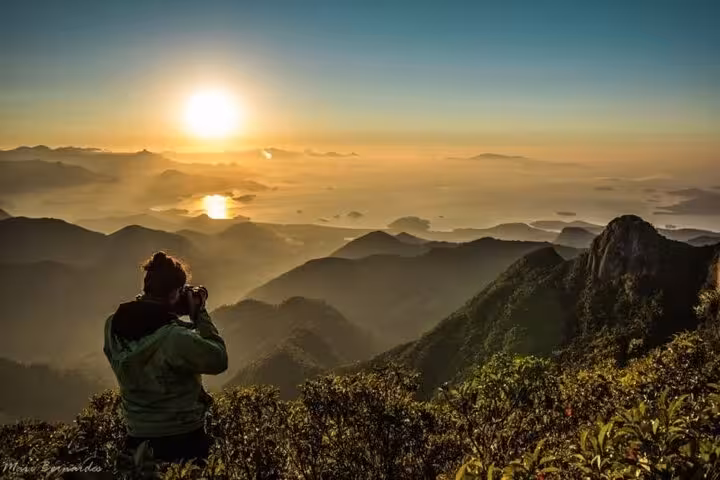 Breathtaking sunrise view from Pedra da Macela with a photographer capturing the misty mountain landscape.