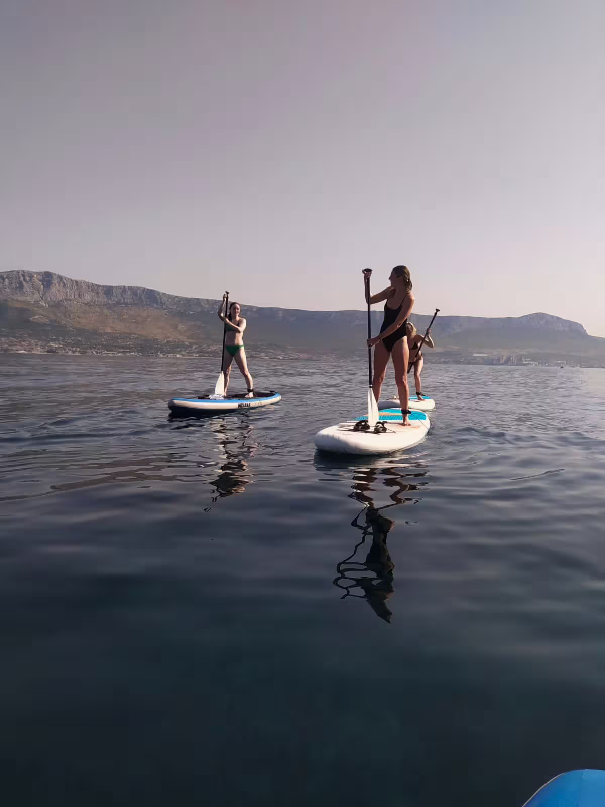Sunrise stand up paddleboarding in Split, Croatia, calm Adriatic sea with mountain views on morning SUP tour