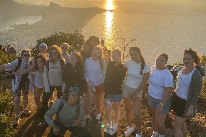 Group enjoying a sunrise view over Rio de Janeiro from Two Brothers Peak with a local guide on a scenic walking tour.
