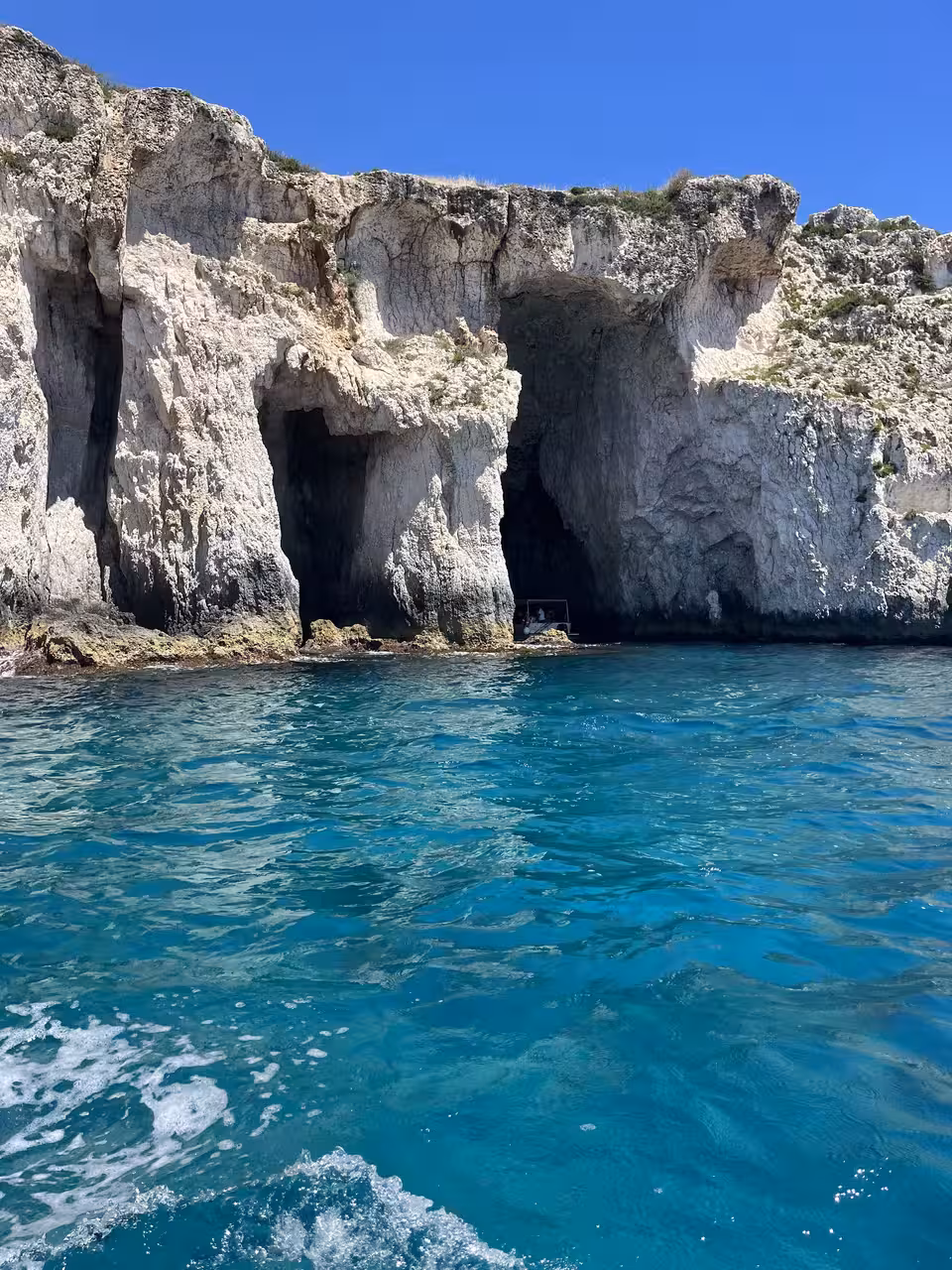 Majestic sea caves with crystal-clear blue waters, a highlight of the Sunset Aperitif Tour.