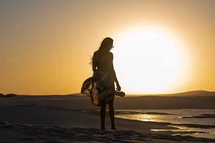 Silhouette on Jericoacoara sand dunes at golden sunset, scenic stop on ATV tour near lagoons and beach views