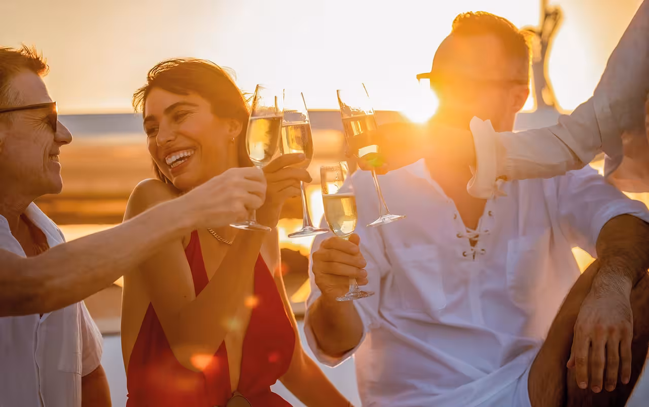 Friends toasting champagne on a boat during a magical Portimao sunset experience tour in the Algarve