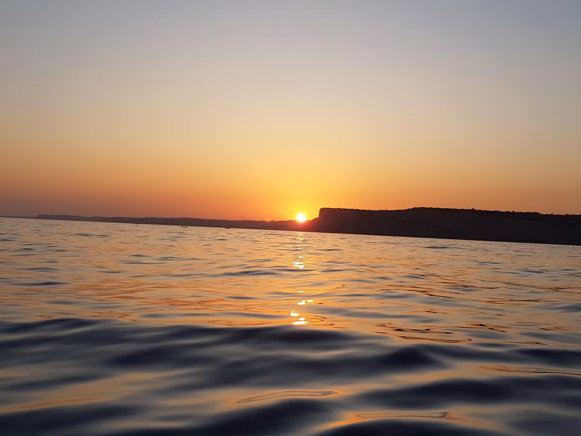 Golden Algarve sunset over calm Atlantic waters during a Ponta da Piedade boat trip from Lagos, Portugal