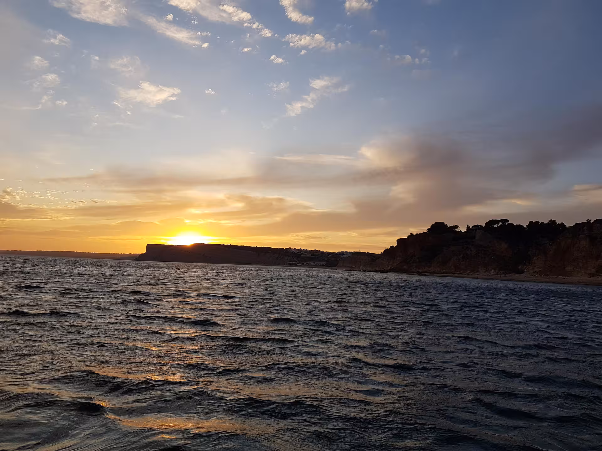 Golden Algarve sunset over the Atlantic Ocean and rugged Ponta da Piedade cliffs viewed from a peaceful Lagos boat tour