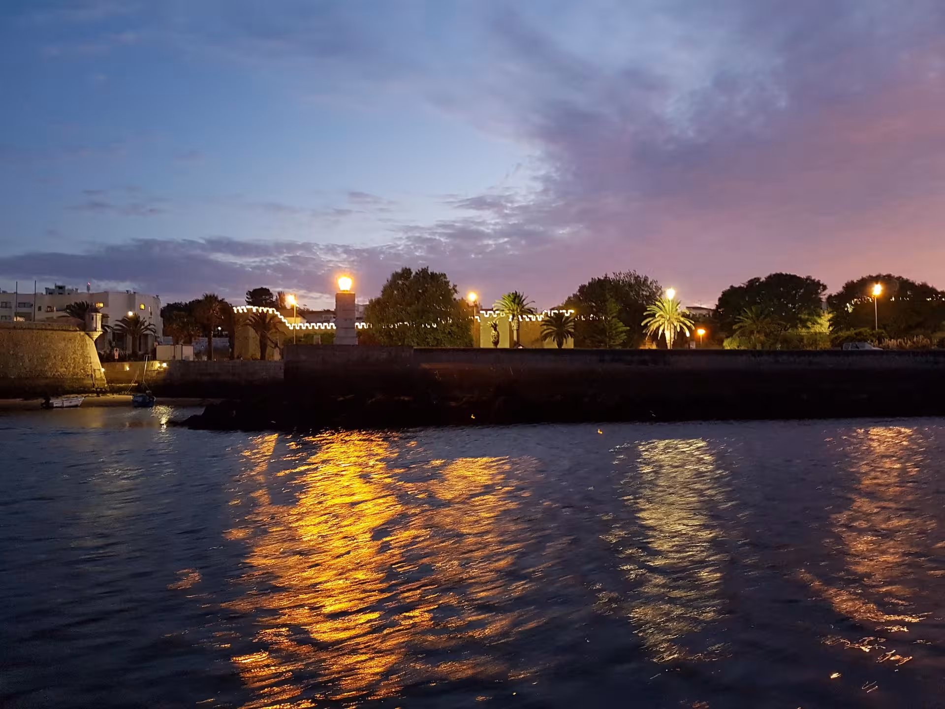 Travelers in life jackets enjoy a sunset boat trip past dramatic rock formations at Ponta da Piedade, Lagos Algarve