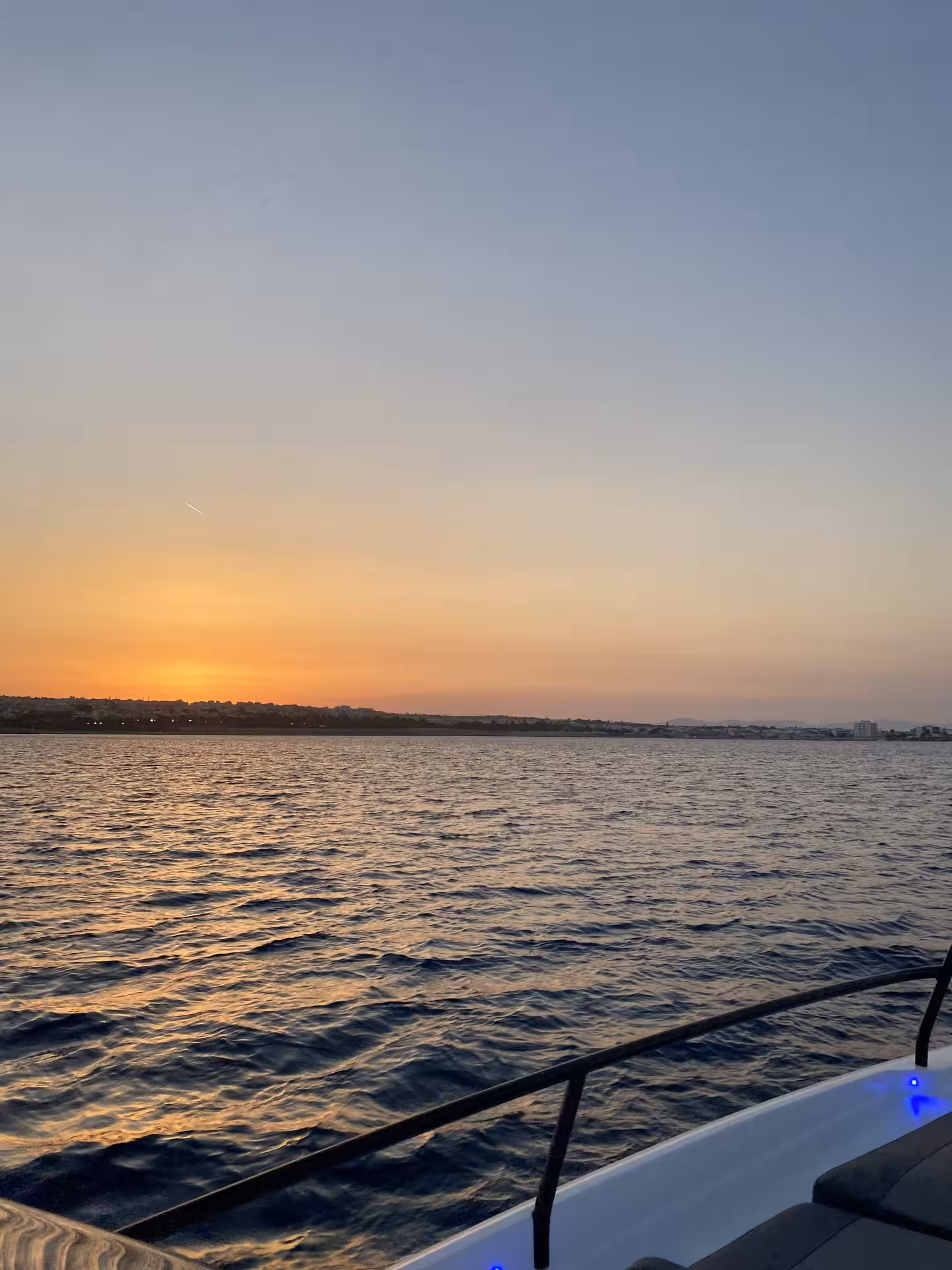 Golden sunset over calm sea viewed from Axopar 25 CT deck on a private sunset cruise along the coast