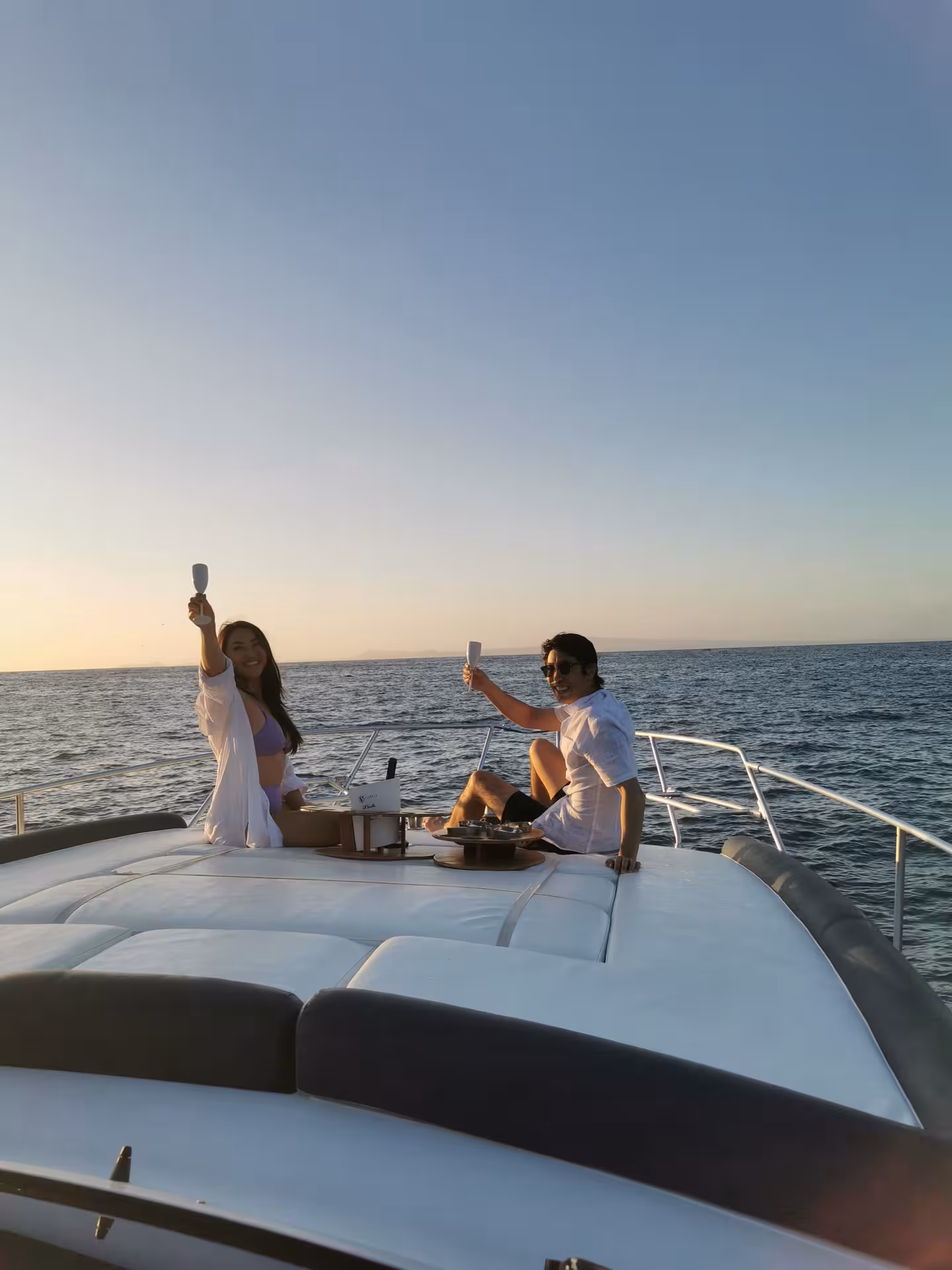 Couple toasting on a 40-feet boat at sunset, enjoying an exclusive cruise from Sorrento.