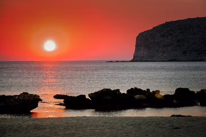 Breathtaking sunset over Falasarna Beach with a vibrant sky and tranquil sea view.