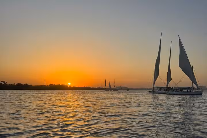 Sunset felucca sailing on the Nile River in Cairo, with traditional boats gliding over golden water views