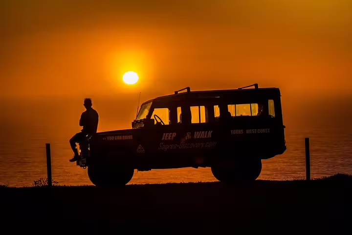 Silhouetted jeep and person at sunset on Algarve West Coast off-road tour.