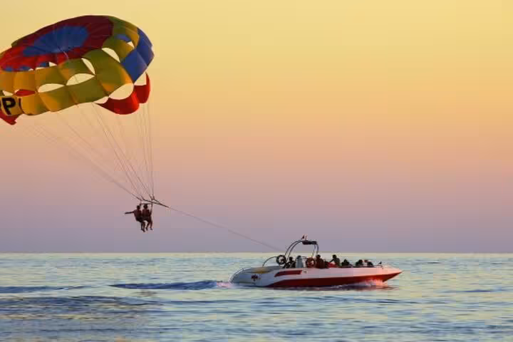 Sunset parasailing in Hurghada over the Red Sea, tandem flyer behind a speedboat on water sports excursion
