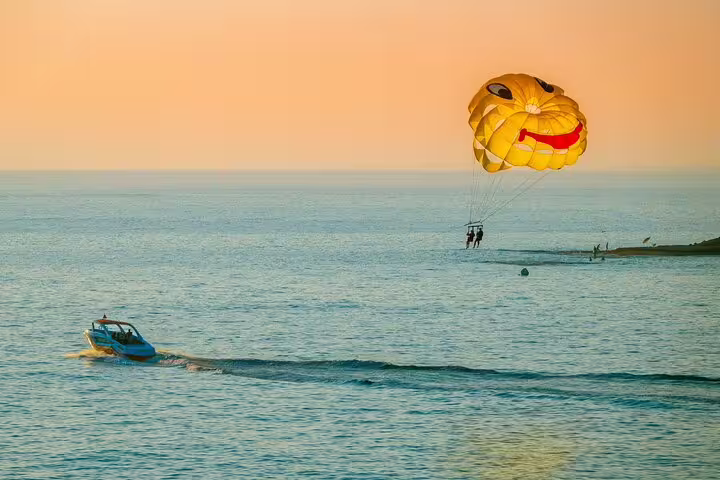 Sunset parasailing in Sharm El Sheikh over the Red Sea, yellow canopy towed by speedboat near shore