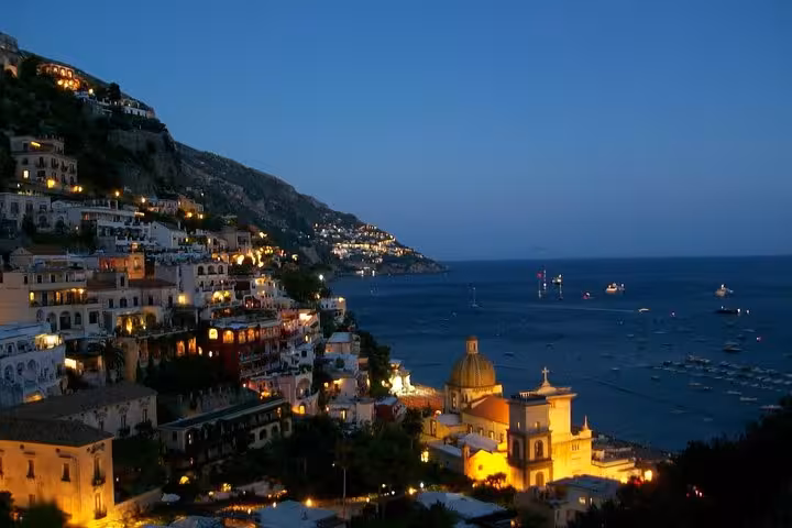 Twilight overlooking Positano's charming coastline with twinkling lights and the Mediterranean Sea, perfect for sunset exploration.