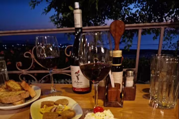 Romantic evening dining setup with wine and appetizers overlooking the sunset at Falasarna Beach.