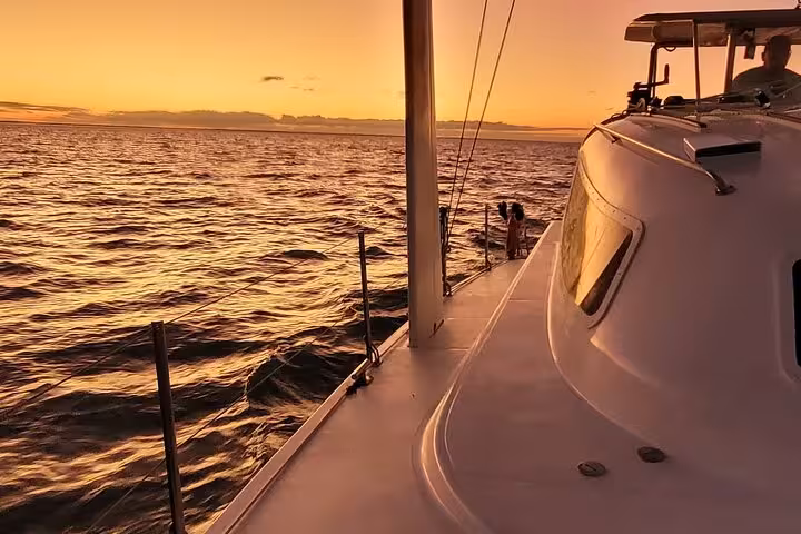 Sunset sailing on Velas do Rio catamaran deck with golden ocean views during 3-hour shared tour