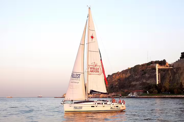 Sailing tour on the Tagus River near Lisbon's scenic cliffs during a picturesque sunset.