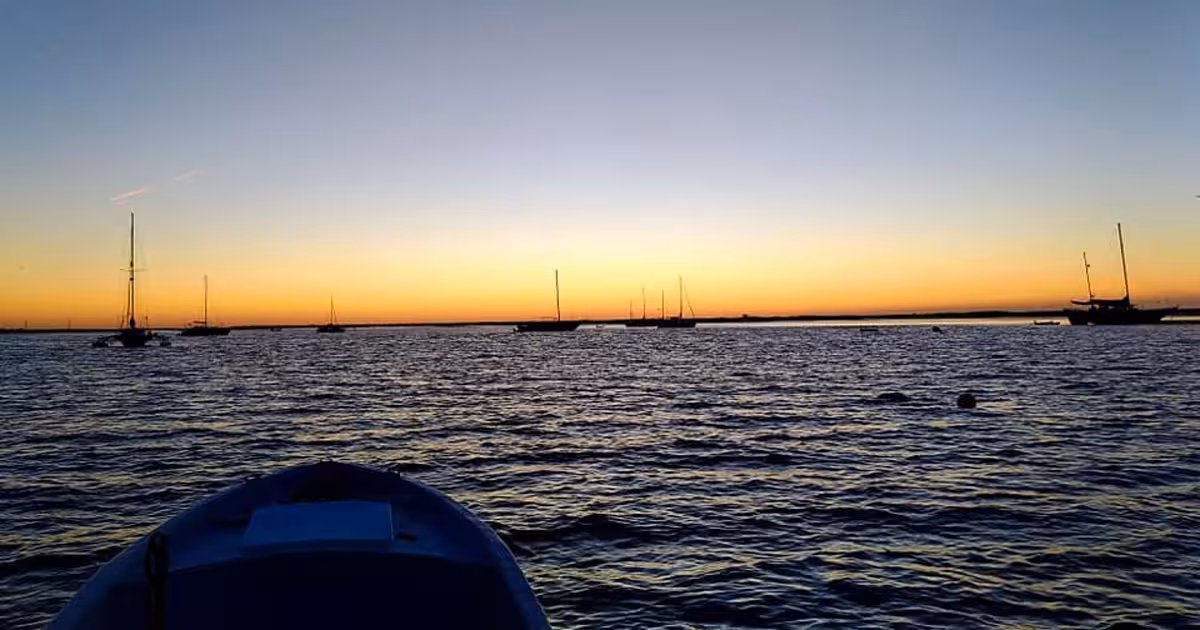 Majestic sunset view with silhouetted sailboats on tranquil waters, capturing the essence of a private sunset tour.