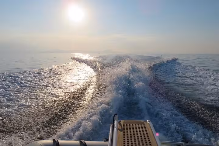 Boat wake sparkling in evening sun on open water, capturing the thrill of a private sunset yacht cruise at sea