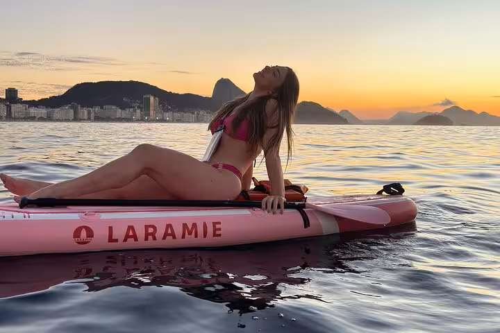 Experience serene sunrise paddleboarding at Copacabana with stunning views and vibrant skies on a SUP tour.