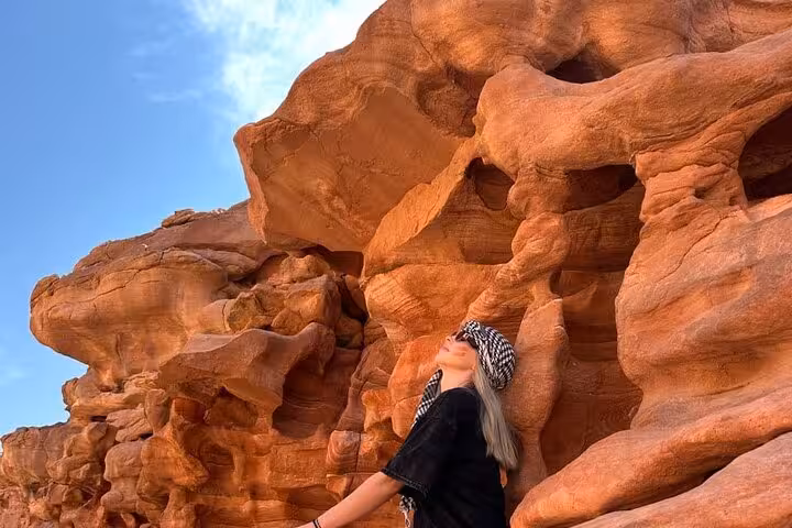 Traveler by red sandstone walls in Super Colored Canyon jeep adventure from Sharm El Sheikh to Blue Hole