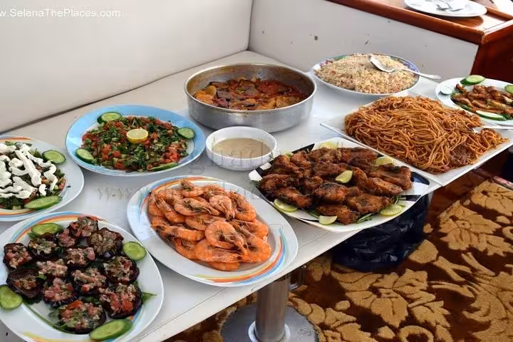 Seafood lunch spread on Super Giftun Island tour boat with shrimp, grilled fish, salad, rice and pasta