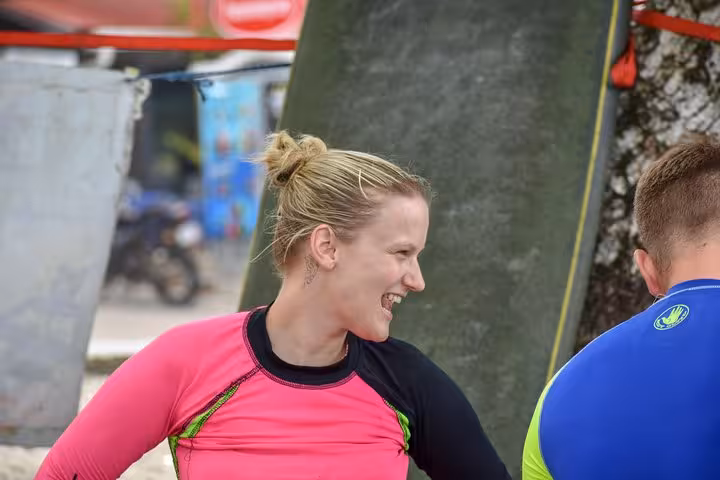 Surf instructor in pink rash guard smiling during a surf lesson in Manuel Antonio, Costa Rica.