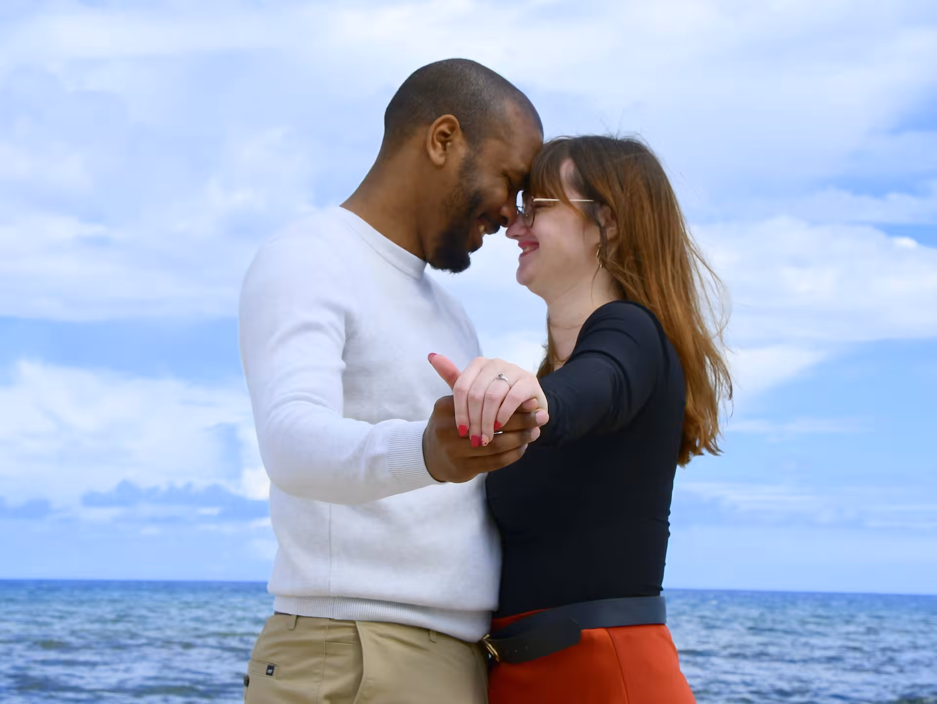 Couple embracing by the sea during a surprise proposal photoshoot at Heraklion Venetian Port.