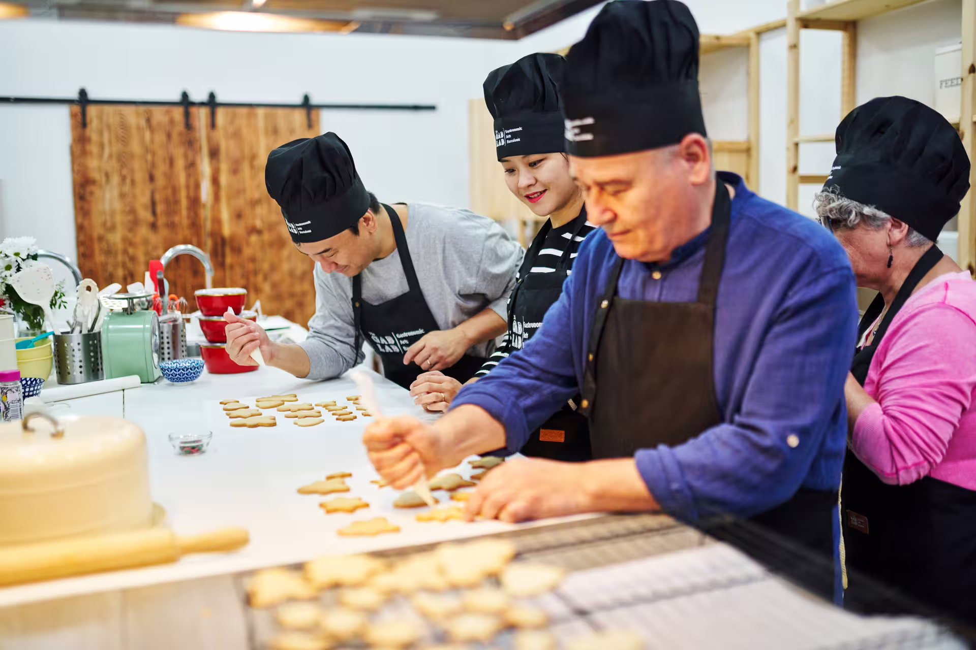 Participants enjoying a hands-on baking experience at the Sweet Escape Bake & Take Workshop, decorating cookies with enthusiasm.