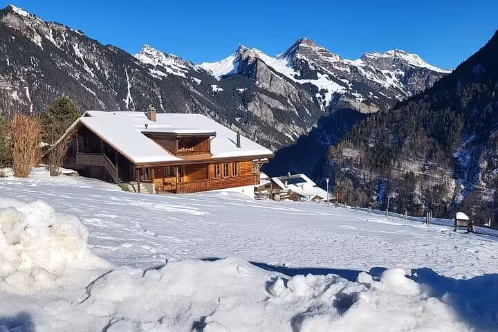 Charming Swiss chalet in snowy Lauterbrunnen with majestic Alps backdrop on a private tour.