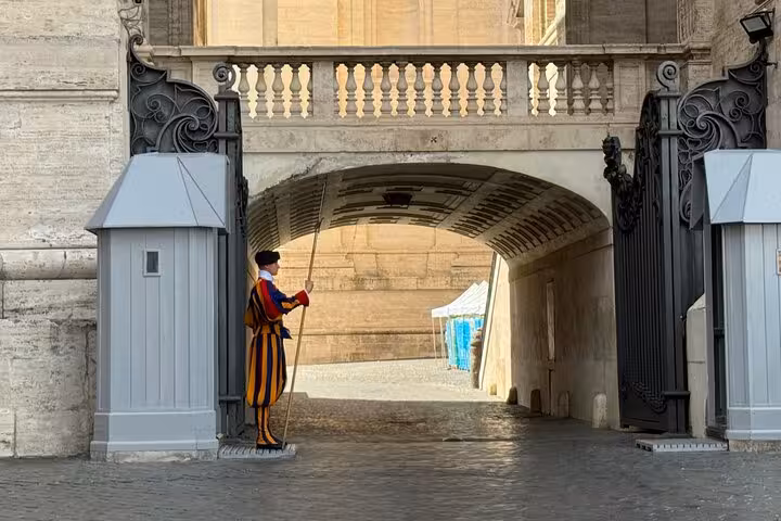 Swiss Guard standing at attention in traditional uniform at Vatican entrance on a St Peter's Basilica private tour.