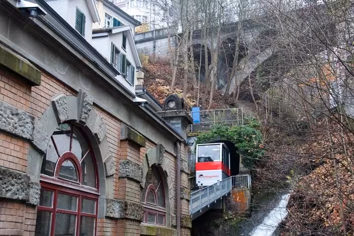 Scenic railway funicular ascending through lush greenery in St. Gallen, highlighting unique Swiss transportation and landscapes.
