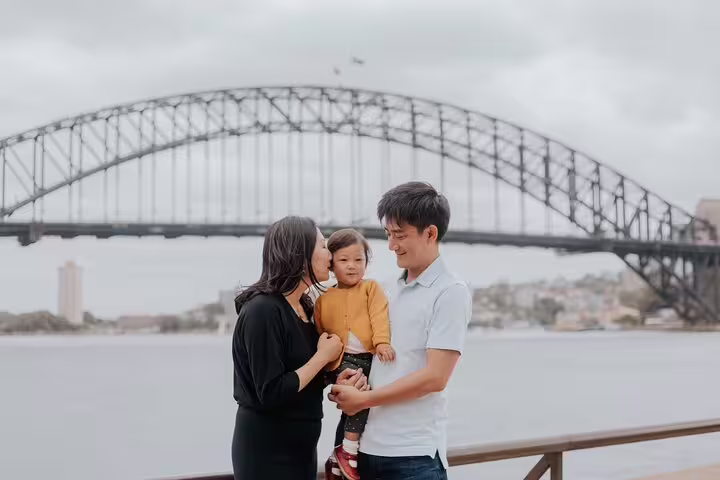 Parents and child by Sydney Harbour with Harbour Bridge view on a private personal travel photographer tour