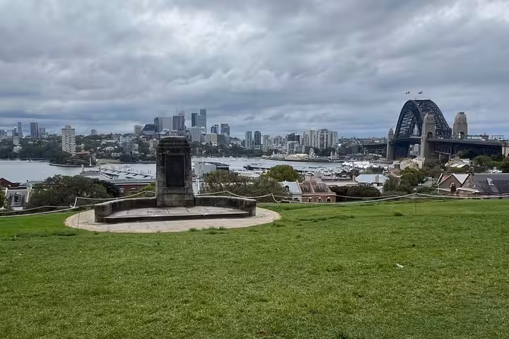 Scenic view of Sydney Harbour Bridge and city skyline from a lush green park during a Sydney private tour.