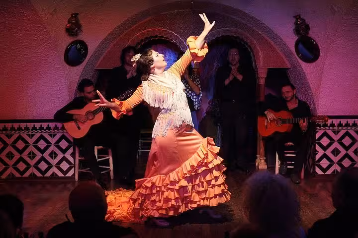 Tablao flamenco show with dancer in ruffled dress, live guitarists and singers, authentic Spanish night