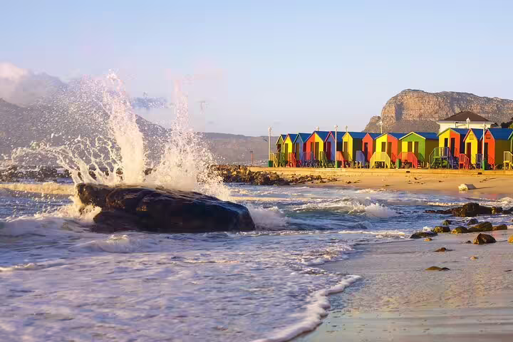 Colorful beach huts and ocean waves at Table Mountain National Park, ideal for coastal scenic tours.