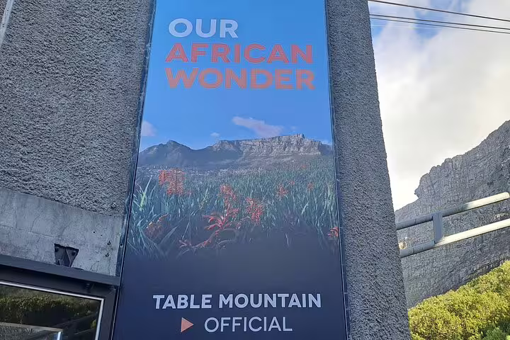 Vibrant sign reading 'Our African Wonder' with a scenic view of Table Mountain, highlighting its official status.