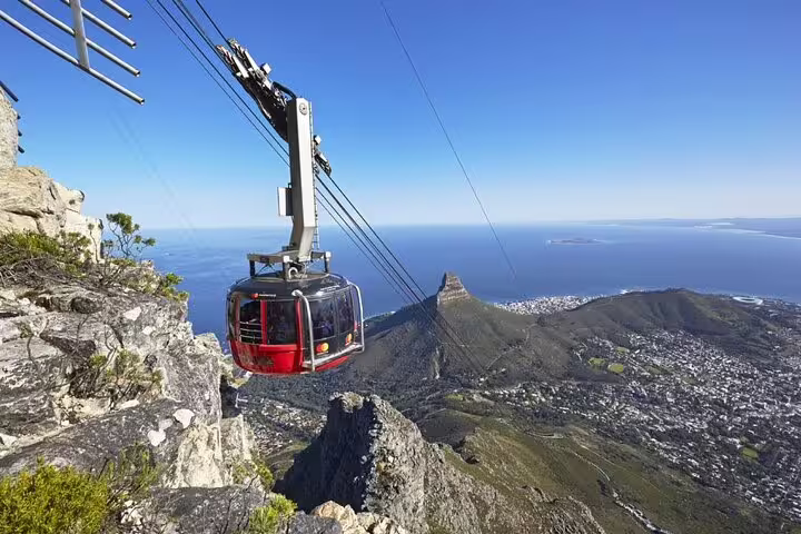 Aerial cable car ascending Table Mountain, offering breathtaking views of Cape Town and the Atlantic Ocean.