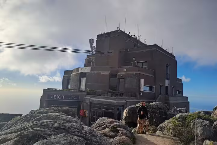 View of the Table Mountain cable car station with rocky landscape and cloudy sky in Cape Town, perfect for exploring.