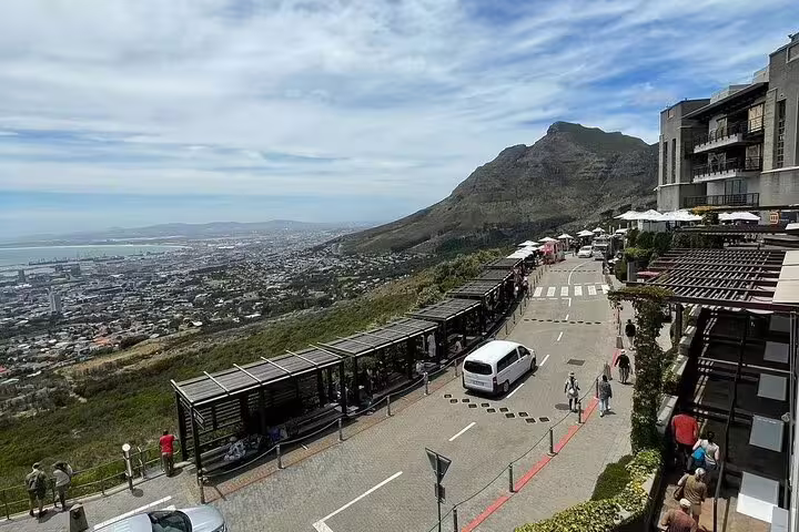 Panoramic view from Table Mountain showcasing Cape Town cityscape and coastline, accessible via cable car experience.