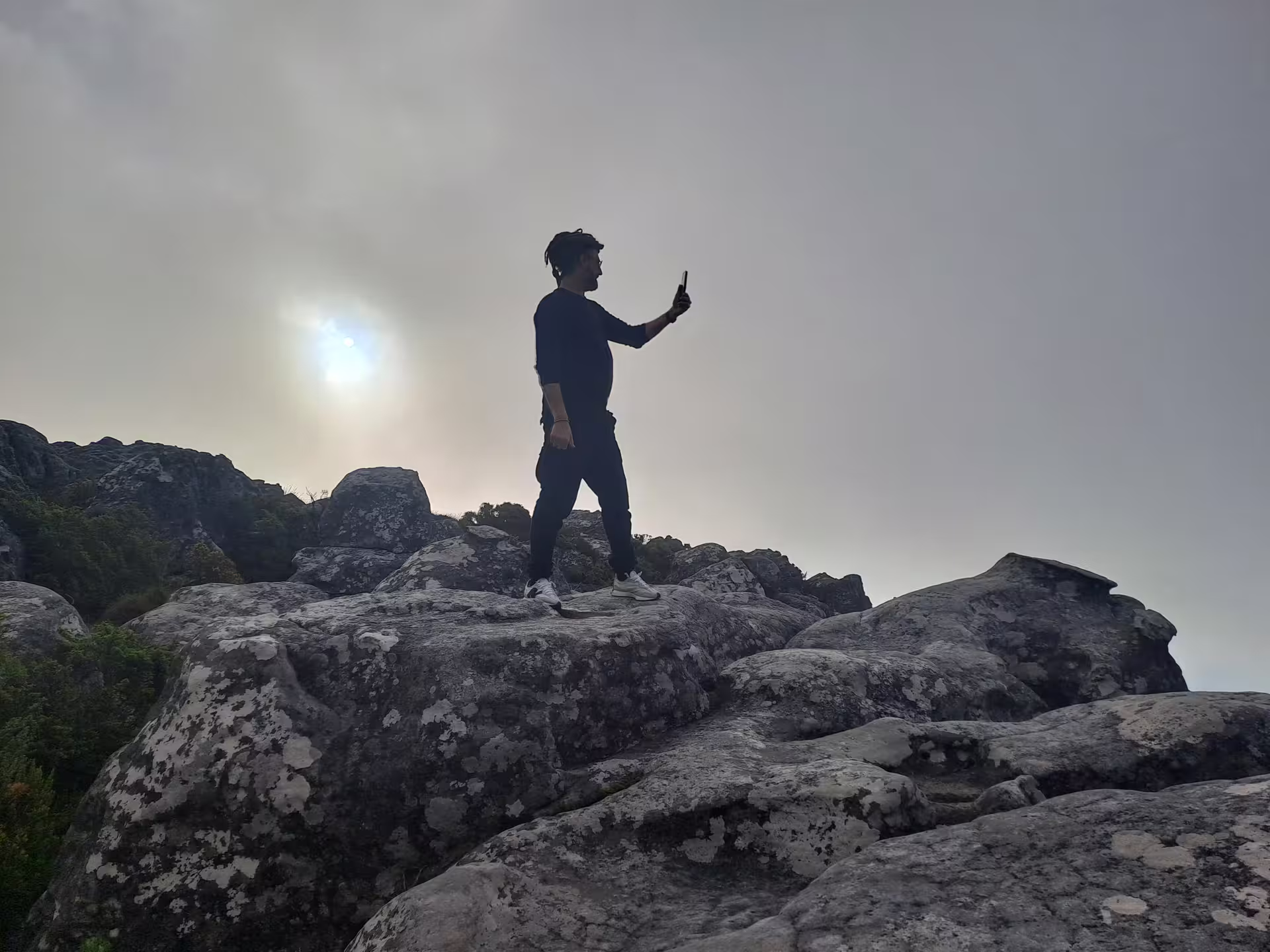 Traveler takes selfie atop Table Mountain, capturing stunning views on a shared cable car tour in Cape Town.